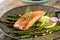 Grilled salmon and asparagus on wooden table close up