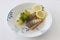 Grilled salmon fish filets on a plate with potatoes, parsley and slices of lemon. Close up stock photo