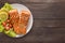 Grilled salmon with lemon, tomato on the wooden background. Copy