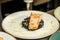 Grilled salmon placed on a plate with black bulgur cook covering with dressing