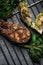 Grilled salmon steak and grilled vegetables on metal grid on grey clay background