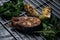 Grilled salmon steak and grilled vegetables on metal grid on grey clay background