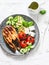 Grilled salmon, zucchini, baked cherry tomatoes and feta cheese - healthy balanced meal on light background