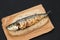 Grilled sardine on bread on black background