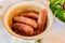 Grilled sausages in cooking pot oreoared outdoors. Rustic style dinner