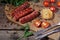 Grilled sausages with tomatoes and corn on a wooden table