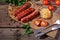 Grilled sausages with tomatoes and corn on a wooden table