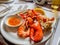 Grilled seafood, shrimps, lobsters, crabs, prawns, served with tasty sour spicy sauce on white dish