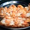 Grilled shrimps lie on a metal tray