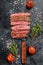 Grilled and sliced Flank rare steak. Marble beef meat. Black background. Top view