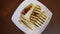 Grilled slices of halloumi cheese on plate top view rotate. Greek goat cheese grilled on beige plate. Stripes gold brown