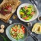 Grilled spare ribs with buckwheat, salad with citrus and grilled liver, salad with tomato and glass of vine. Flat lay. Top view