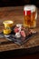 Grilled steak with corn with mushrooms sauce on cutting board and mug of beer on wooden table