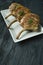 Grilled steaks from pork ribs with spices and herbs. Bone steak. Side view. Dark wooden background