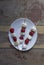 Grilled Strawberry and Marshmallow on wooden skewers in white plate on wooden background