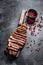 Grilled strip loin steak on a cleaver. The cooking medium. Black background. Top view