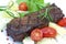 Grilled strip steak with tomato and salad