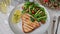 Grilled swordfish steak with fresh salad, tomatoes and cheese on a plate rotating. Christmas New Year decoration.