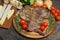 Grilled T bone steak with rosemary, tomatoes, corn, onions and