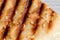 Grilled toast sprinkled with sesame seeds top view. Shallow depth of field
