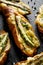 Grilled  toasts, bruschetta with addition of melted cheese, green asparagus, olive oil and herbs on a black background, top view.