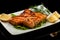 Grilled trout with lemon on a platter on a black table