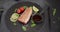 Grilled tuna steak on a black stone serving board with teriyaki soy sauce and pieces of lime