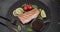 Grilled tuna steak on a black stone serving board with teriyaki soy sauce and pieces of lime