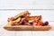 Grilled turkey, cranberry and brie sandwich on a serving board against white wood
