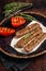 Grilled Urfa shish kebab on a plate with tomato. Dark background. top view