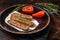 Grilled Urfa shish kebab on a plate with tomato. Dark background. top view