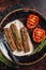 Grilled Urfa shish kebab on a plate with tomato. Dark background. top view