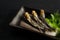 Grilled urume sardines on a black table. A side dish of sake