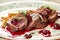 Grilled veal with smashed cherries, closeup.