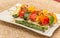 Grilled vegetable and salmon-mango skewer