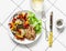 Grilled vegetables, chicken breast and a glass of white wine - delicious healthy diet lunch on a light background, top view