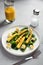 Grilled vegetables and juice on a light stone background, dietary vegetarian snack babycorn, healthy low-calorie food, vertical