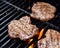 Grilling burgers on a barbecue closeup with flames