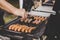 Grilling delicious juicy meat sausages on big grill outdoor