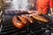 Grilling different kinds of sausages, dry and fresh meat on an open barbeque