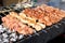 Grilling marinated shashlik on a grill. Shashlik is a form of Shish kebab popular in Eastern, Central Europe and other places.