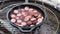 Grilling sausage in cast iron skillet outdoors