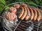 Grilling sausages and beefburgers on a barbecue