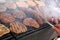 Grilling sausages, burgers, pork steak on barbecues gas grill for party. Hot dogs,sausages and hamburgers on a barbeque, bbq. Smok