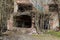 Grim photo of an old dilapidated brick building with collapsed ceilings. The floor inside the building and the ground around it