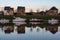 Grimbergen, Flemish Brabant Region, Belgium - Residential houses in a row and boats reflecting in the water of the canal at dusk