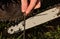 Grinding the chainsaw chain with a round file at the right angle of the cutting and cutting teeth of the blade. logging in leather