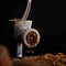 Grinding chocolate dough in meat grinder or mincer on black background. Cooking process, close-up. Working kitchen