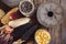 Grinding stones and different species and colors of corns on wooden table, flat lay