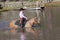 Grinning Cowgirl Crossing Pond